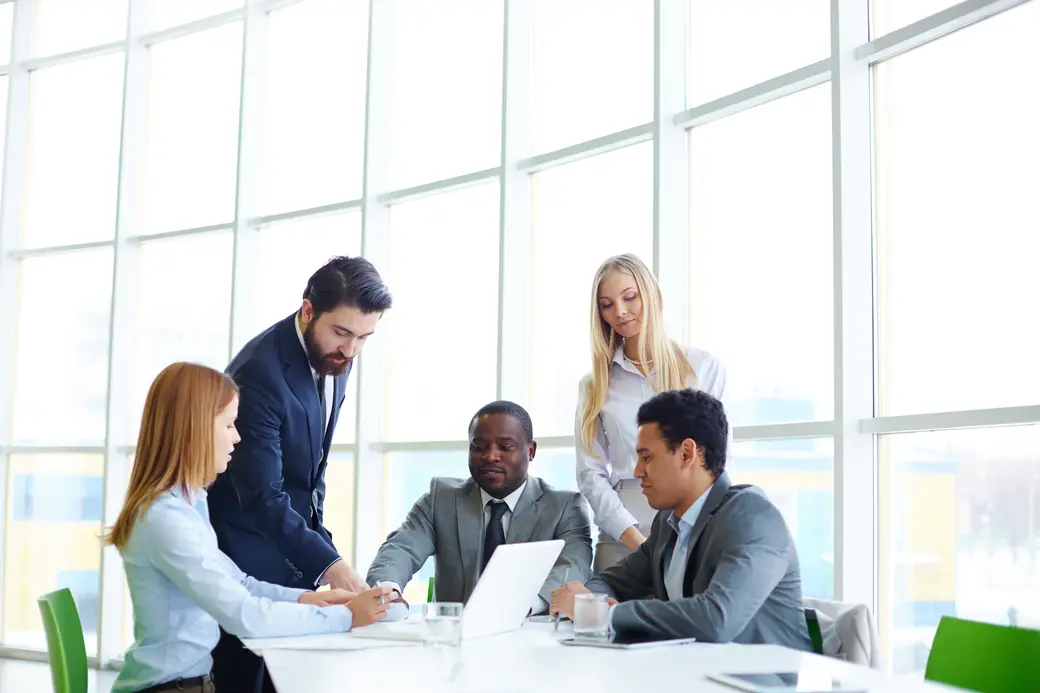 Equipo de profesionales trabajando juntos con un portátil en una reunión